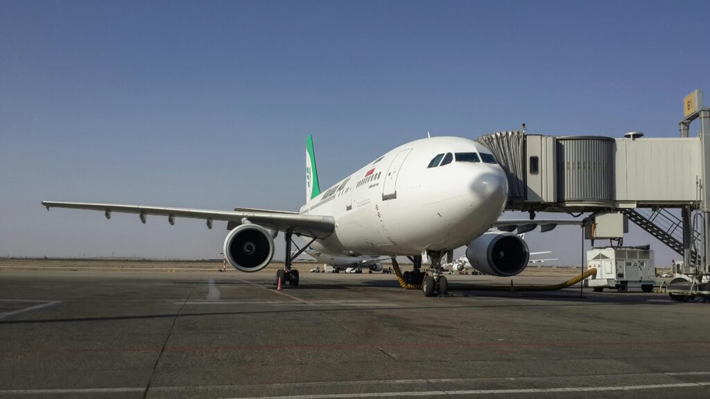 pexels photo 11648289 11648289 A parked airplane at Tehran Imam Khomeini Airport connected to a jetway on a clear day.