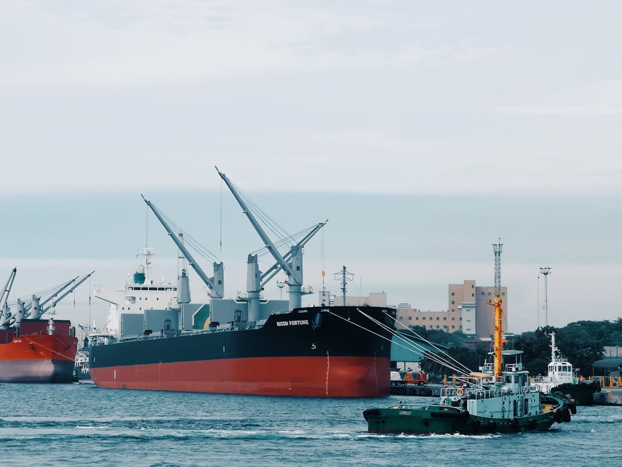 mobile-02 View of cargo ships docked at Davao harbor with tugboat assistance in Philippines.